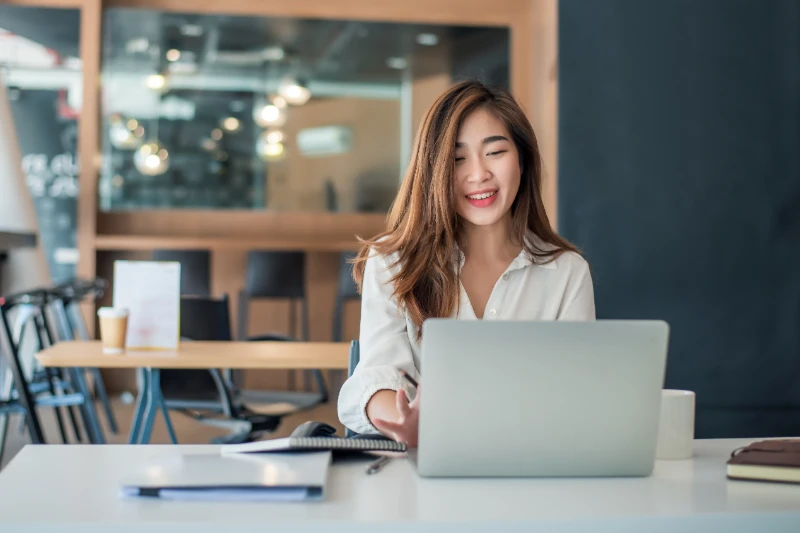 Charming asian businesswoman sitting working on a lptop