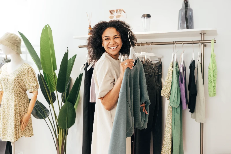 Blog 5 Laughing woman customer choosing sweatshirt in a store