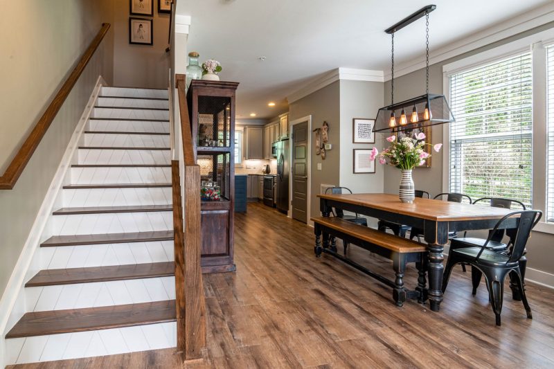 Bright and inviting dining area features a wooden table stai 1784048529
