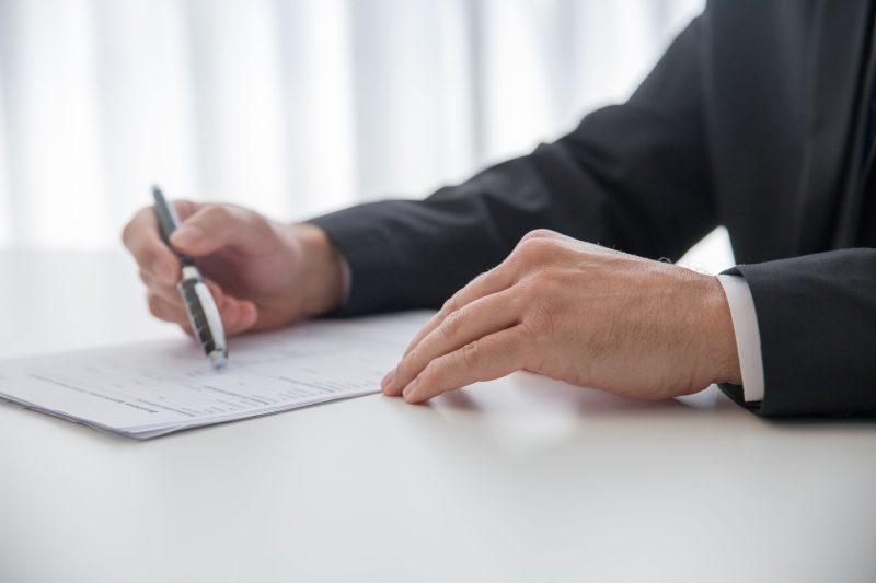 Home 14 Businessman signing important documents at office desk 1785258602